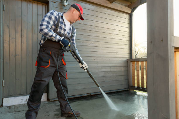 Man is cleaning terrace with a high temperature pressure cleaner on concrete terrace floor