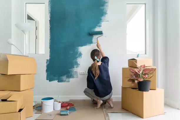 n-happy-woman-painting-interior-wall